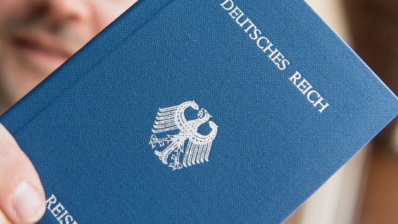 Ein Mann hält ein Heft mit dem Aufdruck "Deutsches Reich - Reisepass" in der Hand. © picture alliance/dpa/Patrick Seeger Foto: Patrick Seeger