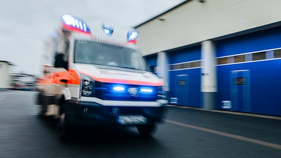 Ein Rettungswagen fährt mit eingeschaltetem Blaulicht über eine Straße. © NDR Foto: Julius Matuschik