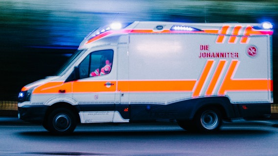 Ein Rettungswagen fährt mit eingeschaltetem Blaulicht über eine Straße. © NDR Foto: Julius Matuschik