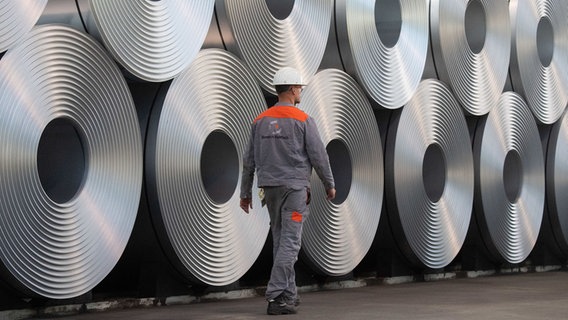Eine Mitarbeiter geht bei der Salzgitter AG an aufgewickeltem Stahl vorbei. © picture alliance/dpa | Julian Stratenschulte Foto: Julian Stratenschulte