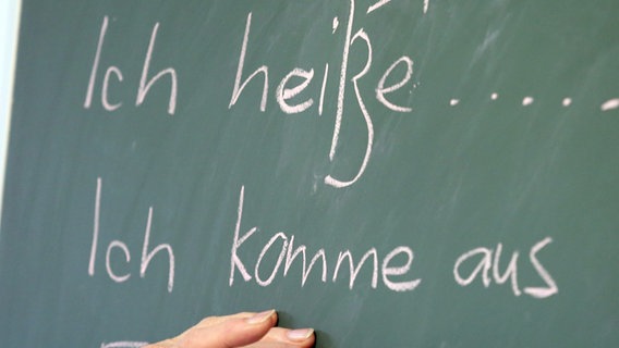 Auf einer Tafel stehen die deutsche Wörter "Ich heiße ..." und "Ich komme aus ...". © dpa - picture alliance Foto: Bernd Wüstneck