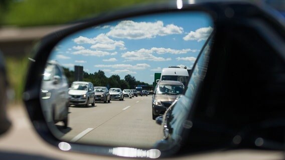 Blick in den Außenspiegel eines Autos, in dem zähfließßender Verkehr auf der Autobahn zu sehen ist. Foto: Mohssen Assanimoghaddam/dpa © picture alliance/Mohssen Assanimoghaddam/dpa Foto: Mohssen Assanimoghaddam