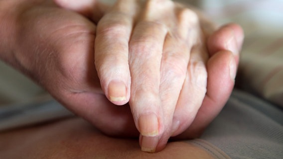 Die Hand einer Pflegerin hält die Hand einer alten Frau. © dpa - Bildfunk Foto: Sebastian Kahnert
