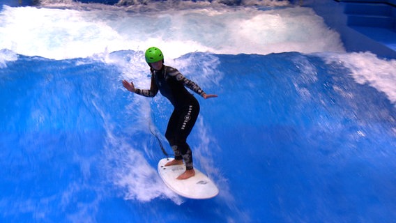 Surf-Anfängerin Sophie Augustin steht sicher auf der Welle. © NDR 