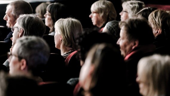 Theaterzuschauer sitzen auf ihren Plätzen und schauen zur Bühne. © picture alliance Foto: Markus Scholz