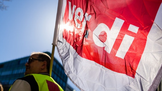 Ein Teilnehmer einer Warnstreik-Kundgebung hält eine ver.di-Fahne. © picture alliance/dpa | Christoph Soeder Foto: Christoph Soeder