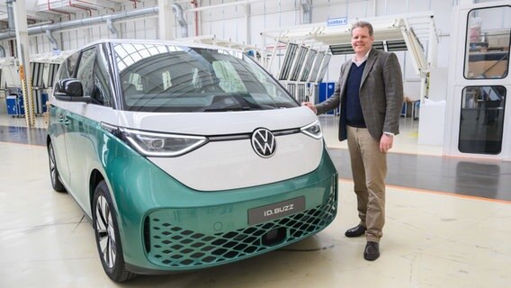 Carsten Intra, Vorstand Volkswagen Nutzfahrzeuge, steht neben einem Elektrobus Volkswagen ID.Buzz im Werk von Volkswagen Nutzfahrzeuge in Hannover. © Julian Stratenschulte/dpa +++ dpa-Bildfunk +++ Foto: Julian Stratenschulte