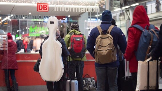 Zugreisende warten in einem Bahnhof vor einem Informationsschalter der Deutschen Bahn. © picture alliance/dpa | Sebastian Kahnert Foto: Sebastian Kahnert