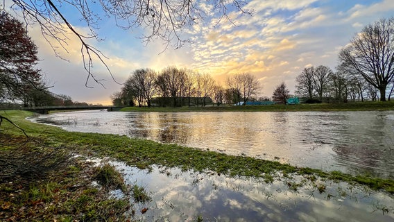 Sonne und Wolken spiegeln sich in einem teis überfluteten Gebiet an einem Gewässer. © NDR Foto: Petra Quade