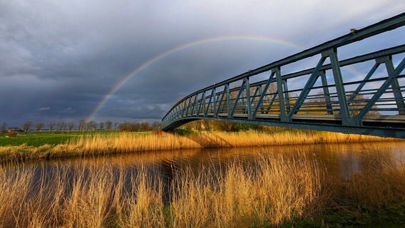 Ein Regenbogen über einer Brücke in Amdorf in Ostfriesland © NDR Foto: Torsten Menge