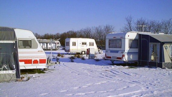 Das Bild zeigt mehrere Wohnanhänger im Winter. © NDR 