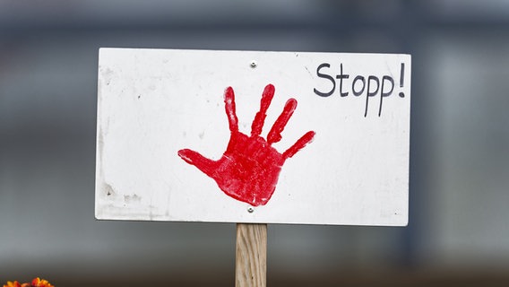 Auf einem weißen Schild ist ein roter Handabdruck sowie der Schriftzug "Stopp!". © picture alliance Foto: Zoonar | HJ Janda