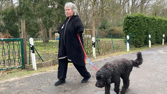Die Contergan-geschädigte Doris Leipelt geht mit ihrem Assistenzhund "Toni" spazieren. © NDR Foto: Simone Mischke