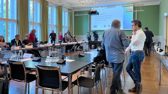 Menschen stehen und sitzen an Tischen in einem großen Raum im Landeshaus in Kiel. © NDR Foto: Constantin Gill