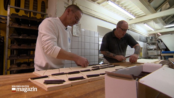 Zwei Mitarbeiter stehen in einer Bäckerei. © NDR 