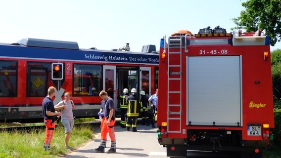 Mehrere Menschen stehen vor einem evakuierten Zug. © nordpresse mediendienst Foto: Heiko Thomsen