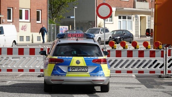 Eine Fahrzeug der Polizei steht vor einer Absperrung. © NDR Foto: Carsten Salzwedel