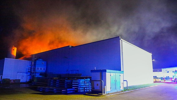 Aus dem Dach einer Lagerhalle schlagen nachts Flammen © Thomas Nyfeler Foto: Thomas Nyfeler
