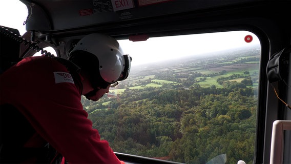Ein Rettungssanitäter blickt aus einem Hubschrauber. © Moritz Ohlsen 