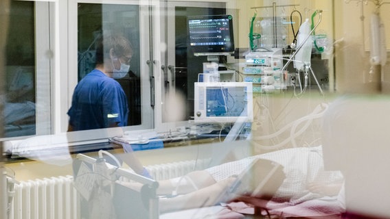 Eike Schröder, Krankenpfleger auf der Intensivstation am Universitätsklinikum Schleswig-Holstein, spiegelt sich in einer Glasscheibe. © picture alliance/dpa Foto: Frank Molter