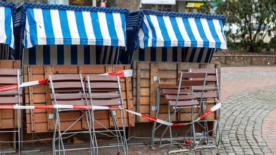 Mehrere Stühle und Tische eines Restaurants sind wegen des Corona-Lockdowns zusammengeklappt. © NDR Foto: Christoph Klipp