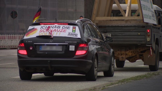 Auf der Kofferraumscheibe eines Pkw ist ein Banner montiert. Auf diesem steht: "Ich hab die Schnauze voll!!! - Strom sparen Ampel ausschalten" © NDR Foto: NDR Screenshot