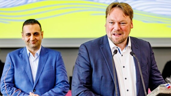 Oliver Kumbartzky (FDP, r), Landesvorsitzender seiner Partei, spricht beim Landesparteitag der FDP Schleswig-Holstein in den Holstenhallen. Bijan Djir-Sarai (FDP), Generalsekretär seiner Partei, steht im Hintergrund. ©  +++ dpa-Bildfunk +++ Foto: Axel Heimken