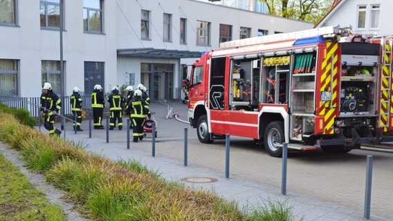 Feuerwehrleute und ein feuerwehrauto stehen vor der Helios-Klinik in Schleswig. © nordpresse mediendienst Foto: Herbert Schmidtke