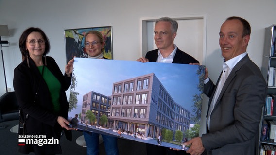 Mehrere Personen halten in den Händen eine Grafik des zukünftigen NDR SH Funkhaus. Ganz links ist die stellvertretende Funkhausdirektorin Bettina Freitag. © NDR 