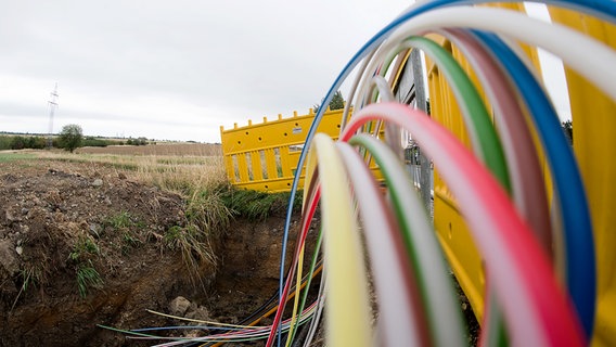 Leerrohre für Glasfaserleitungen für schnelles Internet liegen an einer Landstraße in der Baugrube. © Picture Alliance Foto: Julian Stratenschulte/Picture Alliance