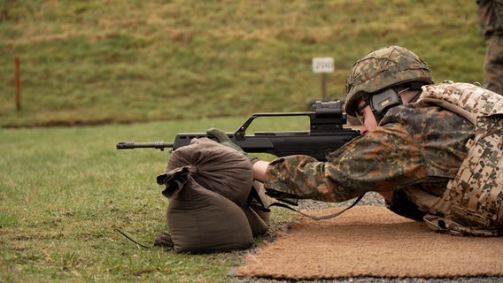 Ein Soldat zielt mit einem Maschinengewehr auf einem Schießstand © NDR Foto: NDR Screenshot