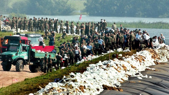 Soldaten und freiwillige Helfer sichern beim Hochwasser 2002 die Deiche in Lauenburg. Soldaten und freiwillige Helfer sichern beim Hochwasser 2002 die Deiche in Lauenburg. © picture-alliance / ZB Foto: Sören Stache