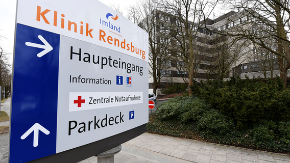 Ein Hinweisschild hängt an einem Gehweg auf am Gelände der imland Klinik Rendsburg. © picture alliance / dpa Foto: Carsten Rehder