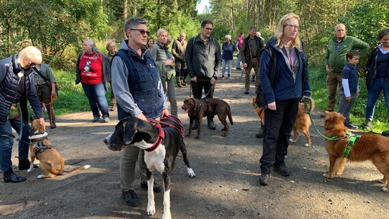 Kadaversuchhunde stehen mit ihren Besitzern im Wald. © Lena Haamann Foto: Lena Haamann