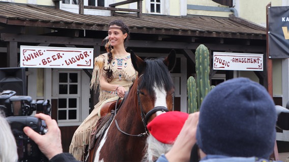 Schauspielerin Nadine Menz sitzt als Indianerin verkleidet auf einem Pferd. © NDR Foto: Tobias Senff