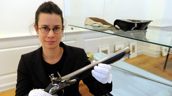 Kuratorin Sonja Kinzler zeigt im Stadtmuseum von Kiel eine dänische Reiterpistole © dpa Bildfunk Foto: Carsten Rehder