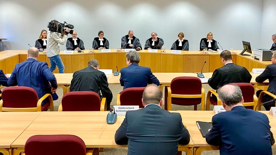 Mehrere Richter sitzen an einem langen Tisch in einem Gerichtssaal des Landesverfassungsgerichts in Schleswig. © NDR Foto: Fabian Boerger