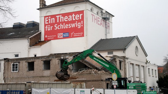 Ein grüner Bagger baut das Gebäude des Schleswiger Landestheaters zurück © SH Landestheater Foto: Angela Möller