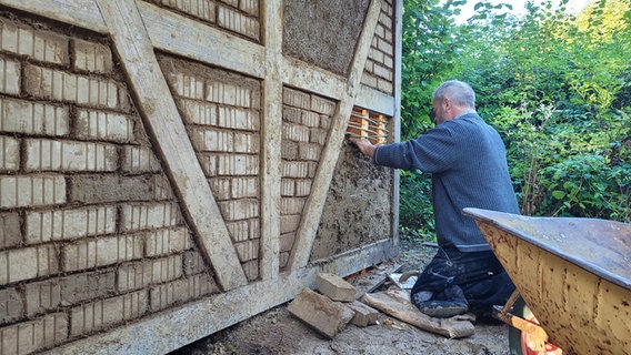Handwerker bei der Fertigstellung einer Lehmhaus Fassade. © Frank Goldenstein Foto: Frank Goldenstein