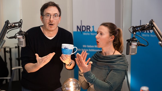 Horst Hoof und Mandy Schmidt präsentieren staunend die exklusive "Leuchte des Morgens"-Tasse. Horst Hoof und Mandy Schmidt präsentieren staunend die exklusive "Leuchte des Morgens"-Tasse. © NDR Foto: Anna-Lena Storm
