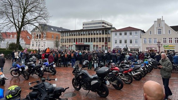 Auf dem Marktplatz in Heide ist eine große Menschenmenge zusammengekommen. Im Vordergrund sind mehrere Motorräder. © NDR Foto: Sofia Tchernomordik