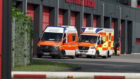 Zwei Einsatzfahrzeuge des Rettungsdienstes stehen vor der Halle der Rettungswache Neumünster. © NDR 