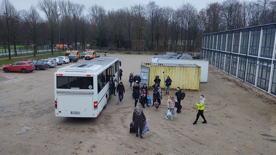 Eine Gruppe Menschen steigen aus einem Bus. © NDR Foto: Peer-Axel Kroeske