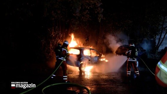 Ein brennendes Fahrzeug wird von Einsatzkräften der Feuerwehr gelöscht © NDR 
