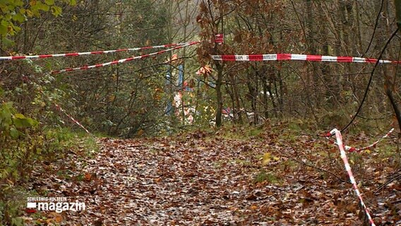 Ein Stück eines Weges ist mit rot-weißen Flatterband abgesperrt. © NDR Foto: NDR Screenshot