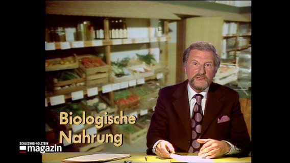 Ein Nachrichtensprecher liest die Nachrichten, in der Ecke steht eine Grafik mit dem Inhalt "biologische Nahrung" © NDR Foto: NDR Screenshots