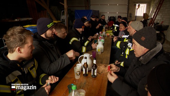 Eine Gruppe von menschen sitzt an einem langen Tisch © NDR Foto: NDR Screenshot