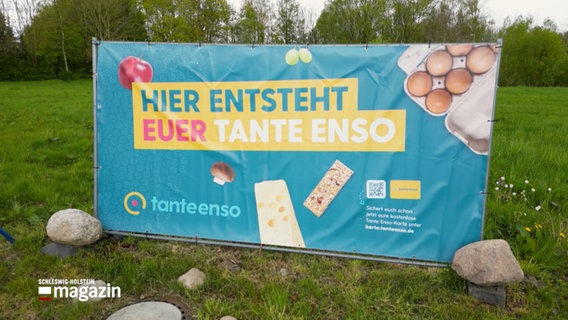 Auf einem Banner auf einem Feld steht: "Hier Entsteht euer Tante Enso" © NDR Foto: NDR Screenshot