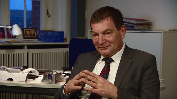 Gerwin Stöcken sitzt in seinem Büro, die Hände vor der Brust. © NDR Foto: Screenshot