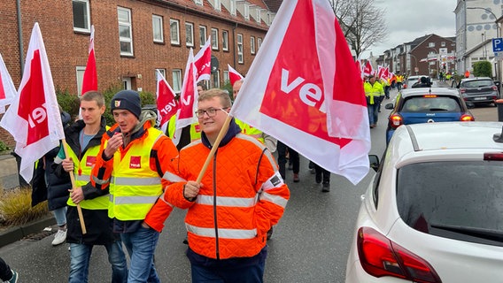 Menschen führen einen Warnstreik in Schleswig durch mit ver.di Flaggen in der Hand. © NDR Foto: Jochen Dominicus